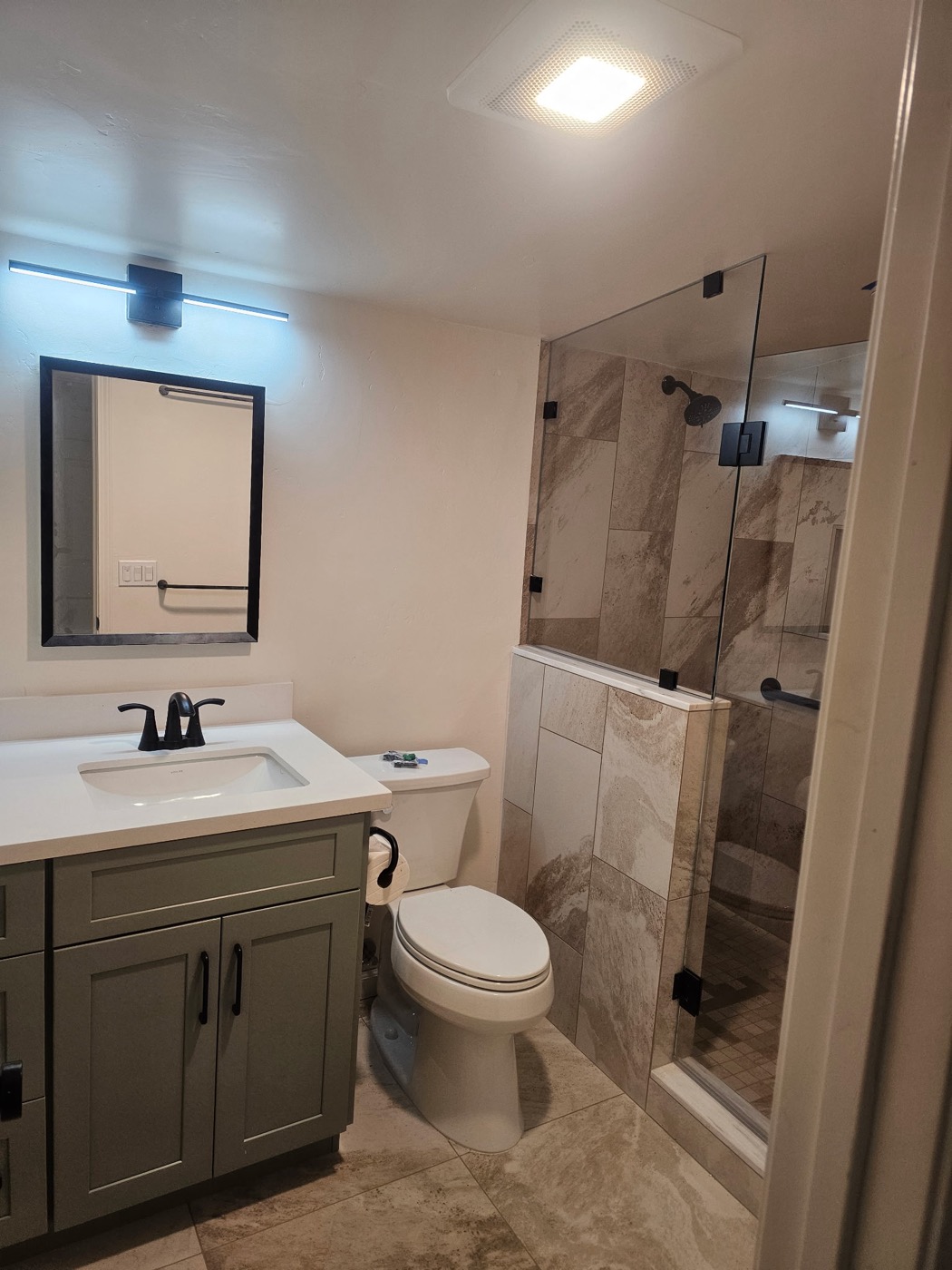 Modern bathroom with sage green vanity and tile shower