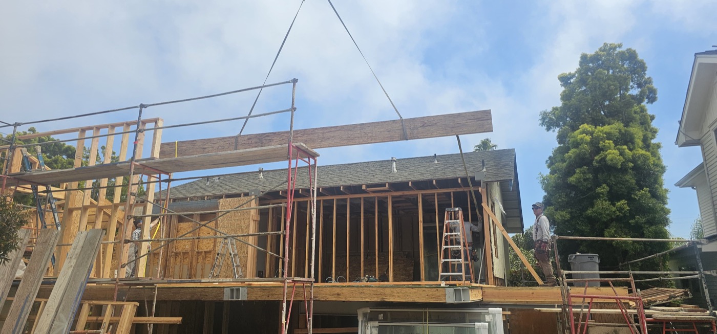 Crew lifting a structural beam during framing