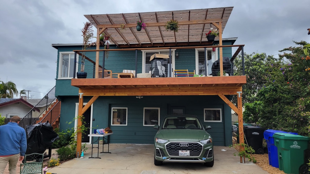 Completed two-story home with deck, pergola and carport
