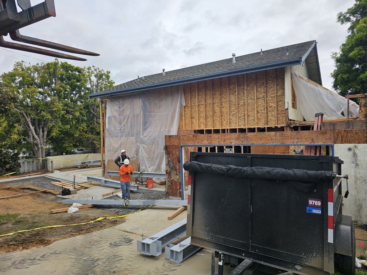 Framing crew on site with OSB sheathing and dumpster