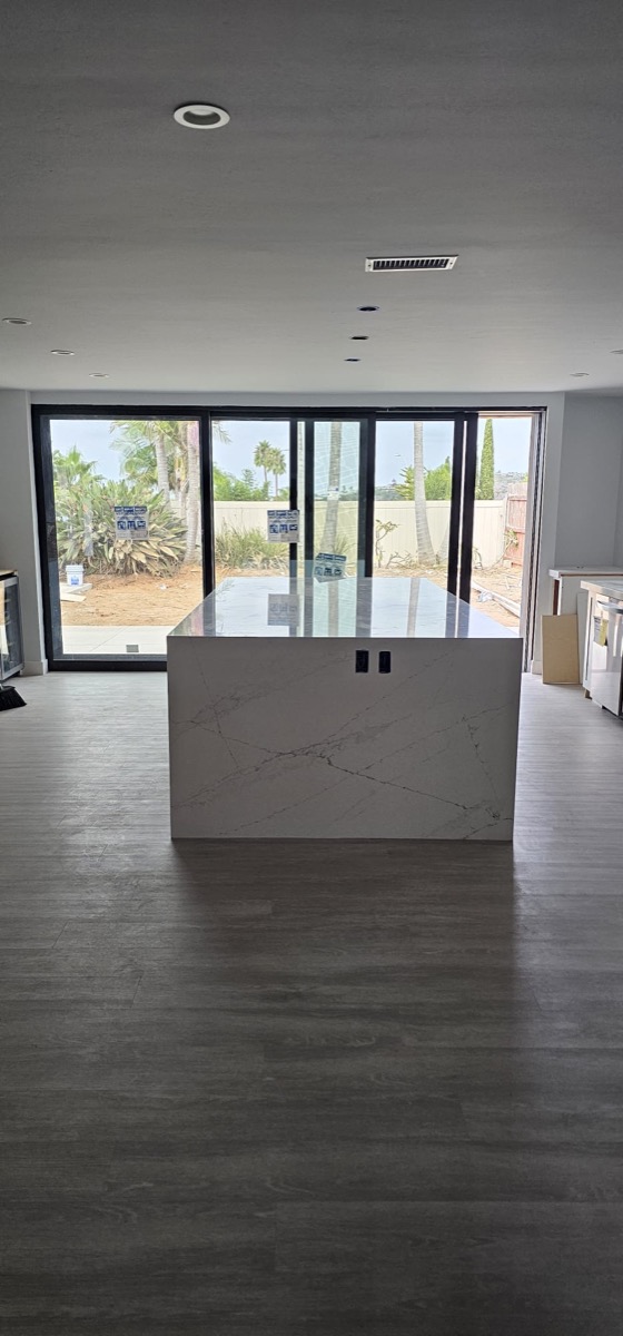 New build kitchen with quartz waterfall island and floor-to-ceiling sliding doors