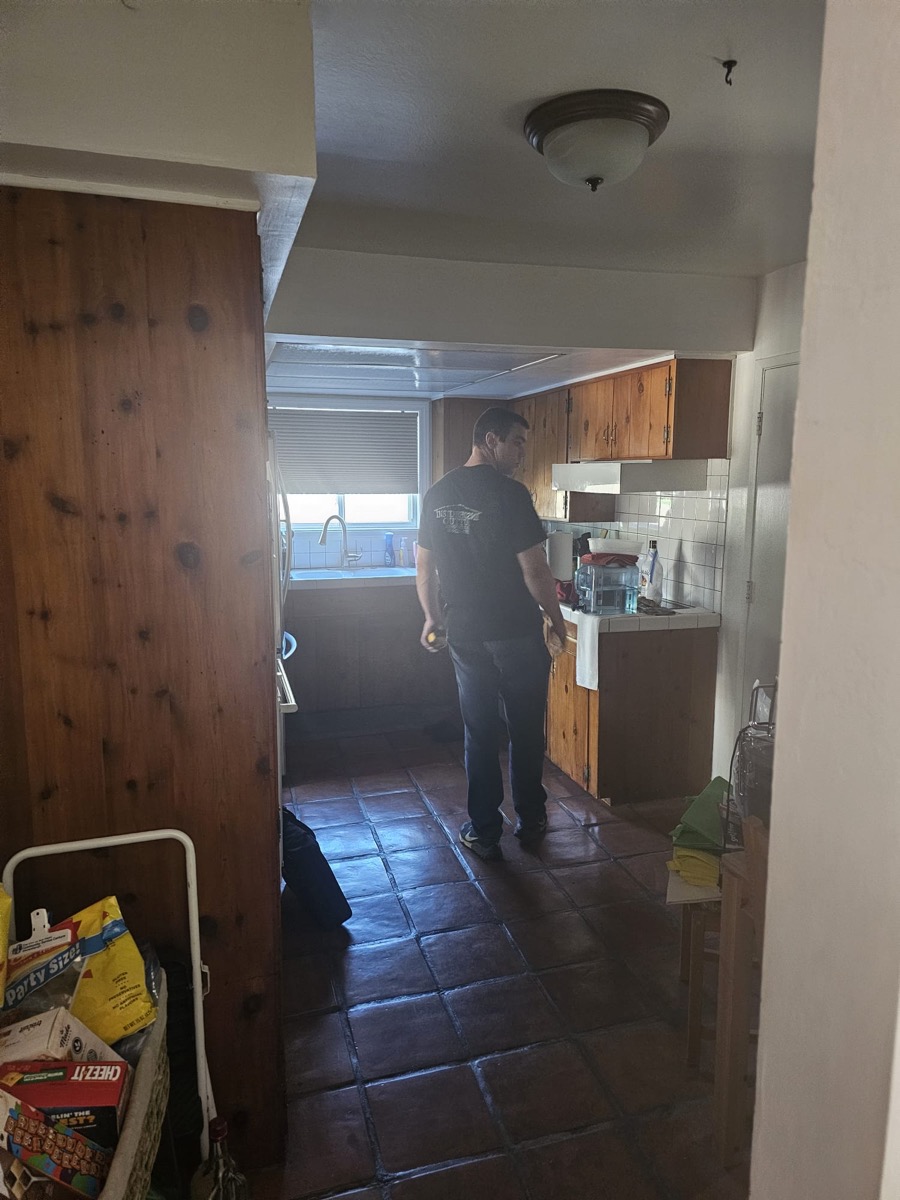 Original kitchen before remodel with wood cabinets and tile floor
